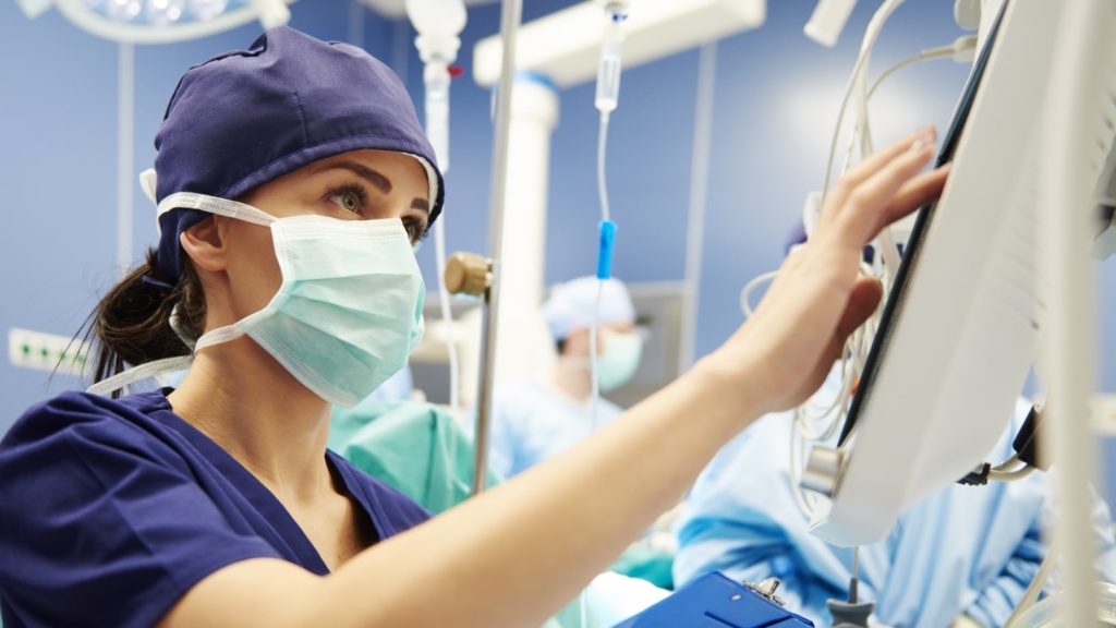 nurse in operating room on device